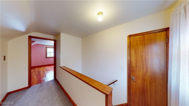 corridor featuring light hardwood / wood-style flooring and lofted ceiling