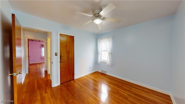 unfurnished bedroom featuring ceiling fan, a closet, and wood-type flooring