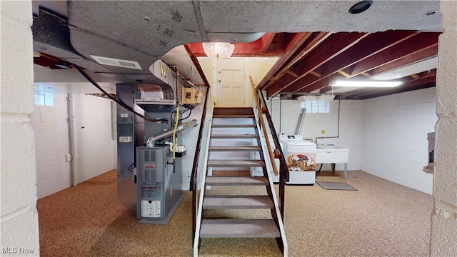 basement with washer / dryer, sink, a wealth of natural light, and heating unit