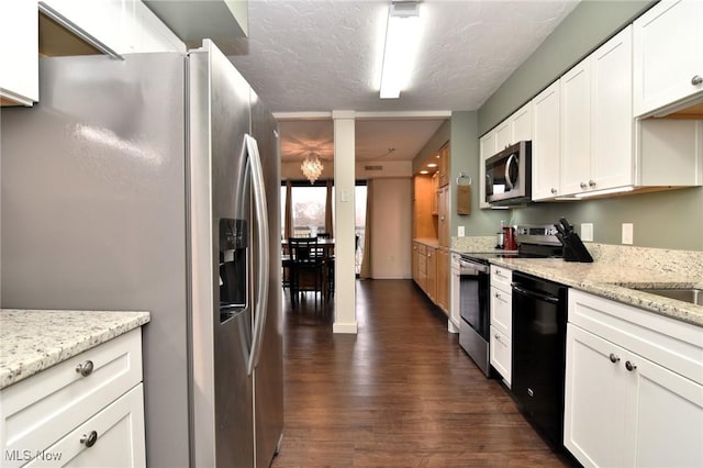 kitchen with white cabinets, dark hardwood / wood-style flooring, stainless steel appliances, and light stone countertops