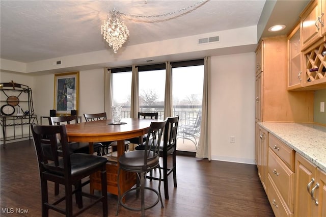 dining area featuring dark hardwood / wood-style flooring and an inviting chandelier