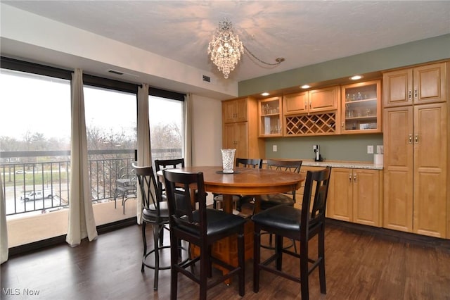 dining room featuring a wealth of natural light, dark hardwood / wood-style flooring, and a chandelier