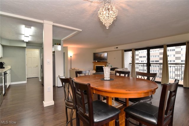 dining area featuring dark hardwood / wood-style flooring, a textured ceiling, and a chandelier