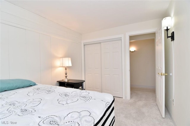 bedroom featuring light carpet and a closet