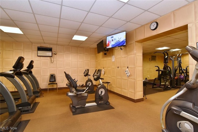 exercise room with carpet flooring and a paneled ceiling