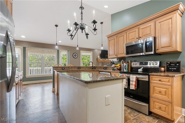 kitchen featuring kitchen peninsula, appliances with stainless steel finishes, an inviting chandelier, and pendant lighting