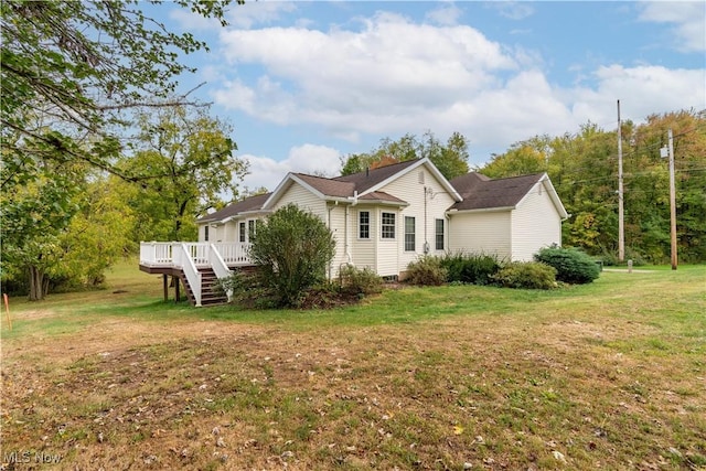 view of side of property featuring a yard and a wooden deck