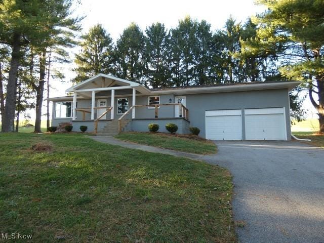 single story home featuring a porch, a garage, and a front lawn