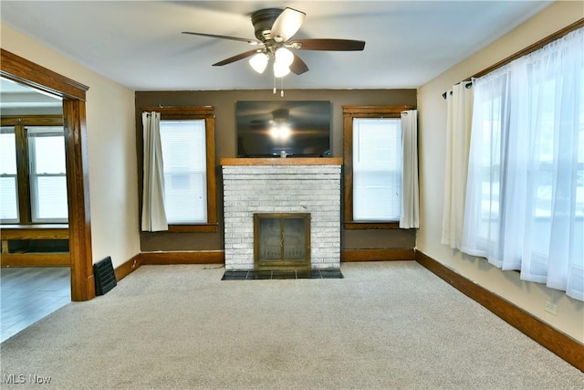 unfurnished living room featuring a wealth of natural light, a fireplace, and light colored carpet