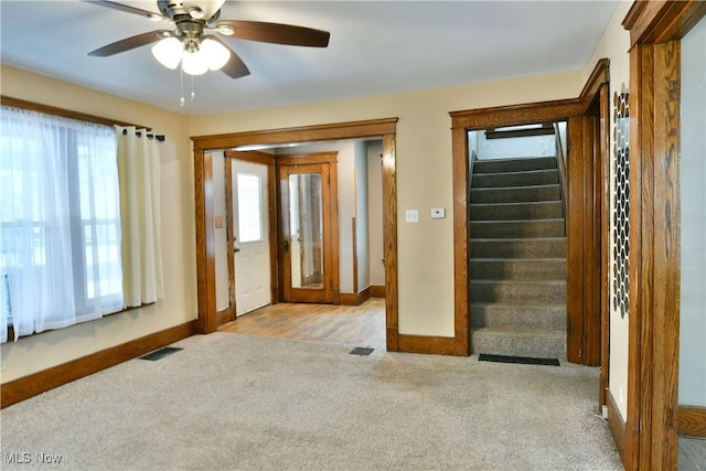 carpeted foyer entrance with ceiling fan