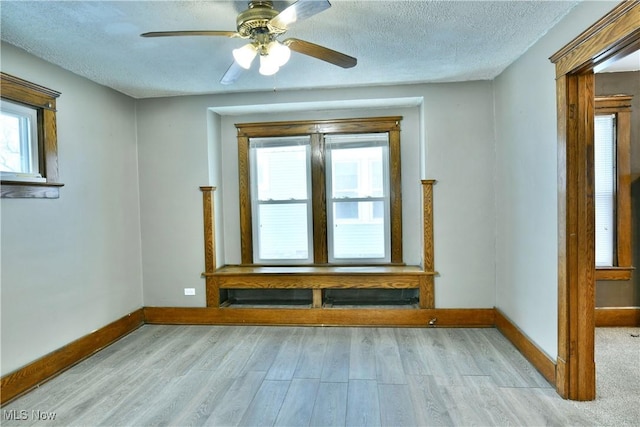 spare room with ceiling fan, light hardwood / wood-style floors, and a textured ceiling