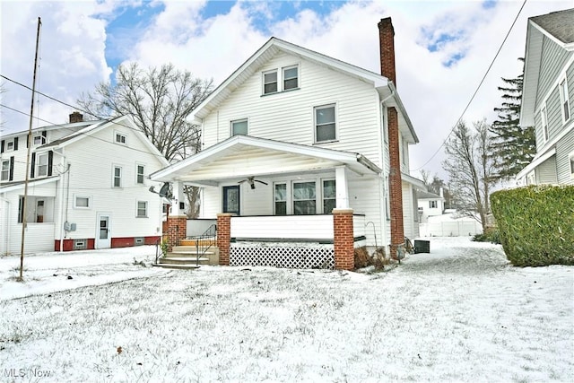 snow covered house featuring a porch