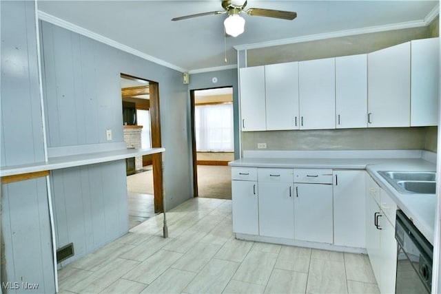 kitchen with ornamental molding, ceiling fan, sink, black dishwasher, and white cabinetry