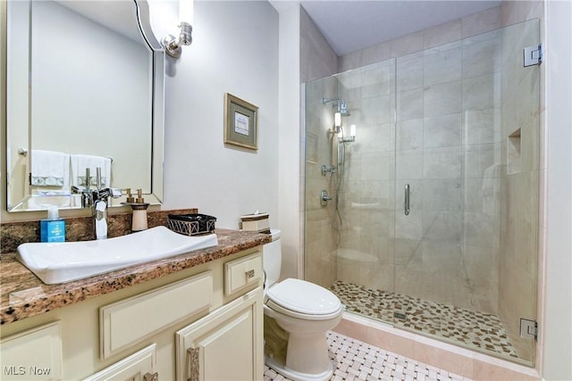 bathroom with tile patterned flooring, vanity, toilet, and a shower with shower door