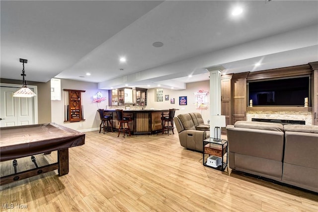 living room with light wood-type flooring, billiards, and bar area