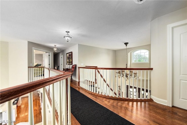 hallway with a chandelier and hardwood / wood-style flooring