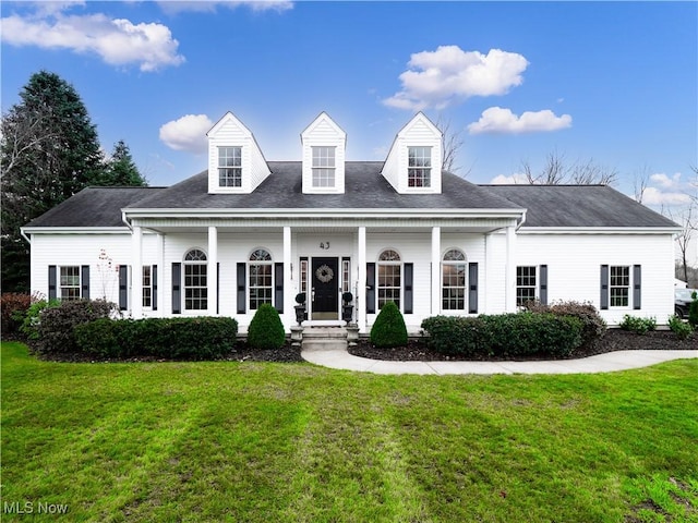 cape cod house featuring covered porch and a front lawn