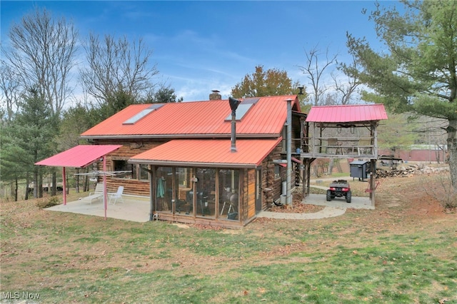 back of property with a lawn and a patio area