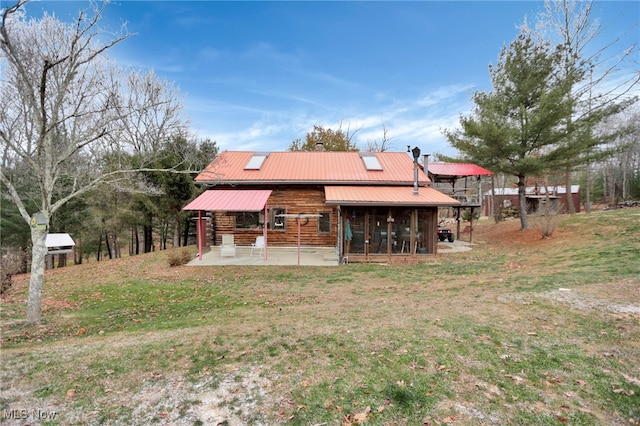 back of property with a lawn and a sunroom