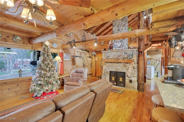 living room featuring a fireplace, lofted ceiling with beams, light hardwood / wood-style floors, and plenty of natural light