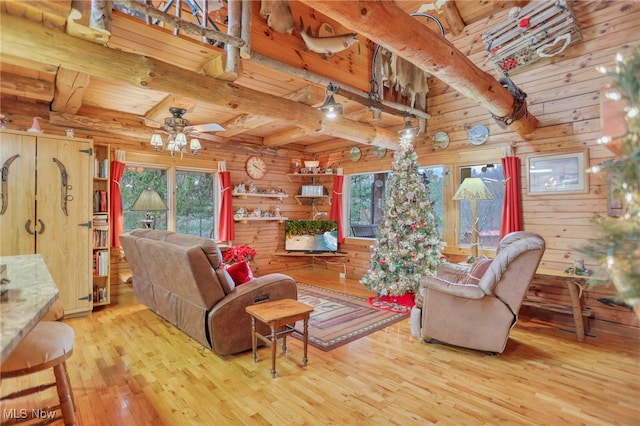 living room featuring ceiling fan, beamed ceiling, wood walls, hardwood / wood-style floors, and wood ceiling