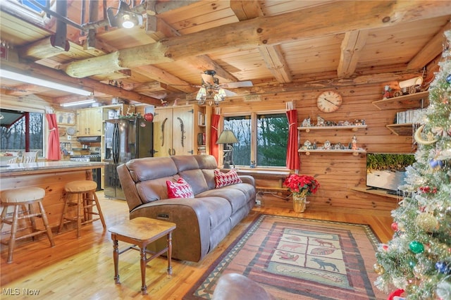 living room featuring wood ceiling, ceiling fan, beamed ceiling, light hardwood / wood-style floors, and wood walls