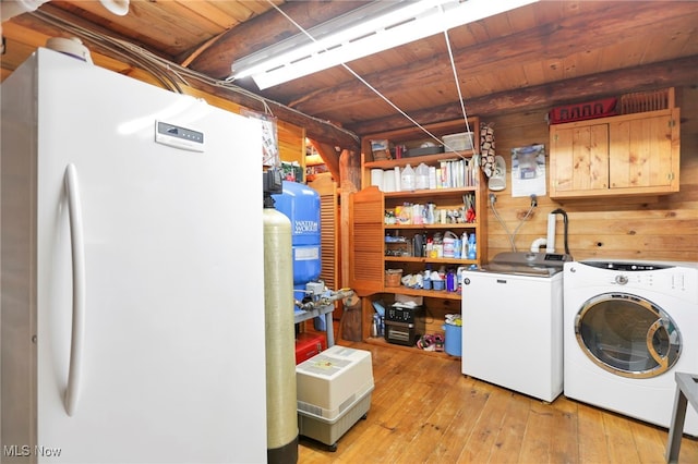 laundry area with washer and clothes dryer, wood walls, cabinets, wooden ceiling, and light wood-type flooring