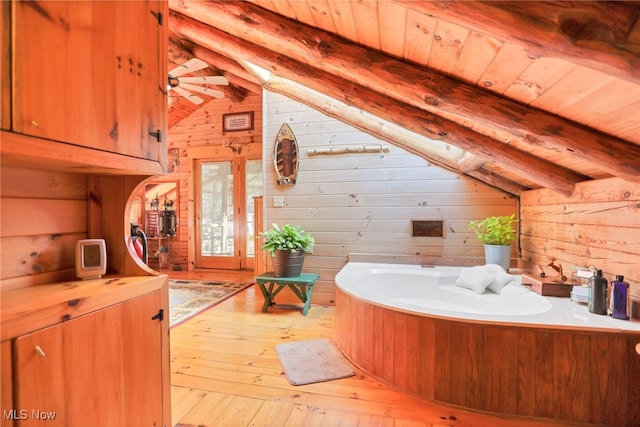 bathroom featuring wood ceiling, wooden walls, wood-type flooring, lofted ceiling with beams, and a bathing tub