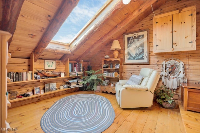 living area featuring lofted ceiling with skylight, light hardwood / wood-style flooring, wooden ceiling, and wooden walls