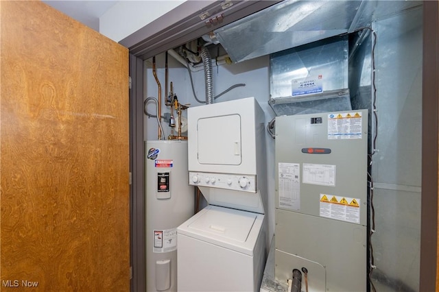 laundry room with electric water heater and stacked washer and clothes dryer