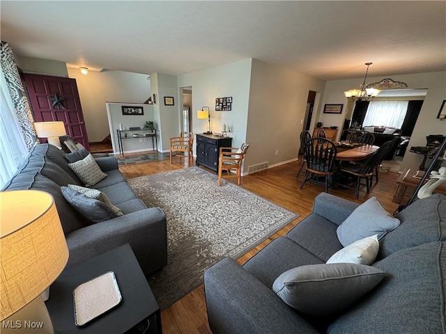 living room featuring an inviting chandelier and hardwood / wood-style flooring