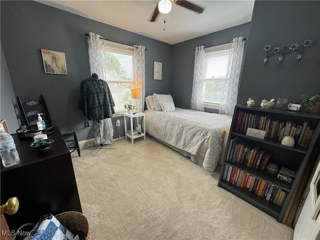 carpeted bedroom featuring ceiling fan and multiple windows