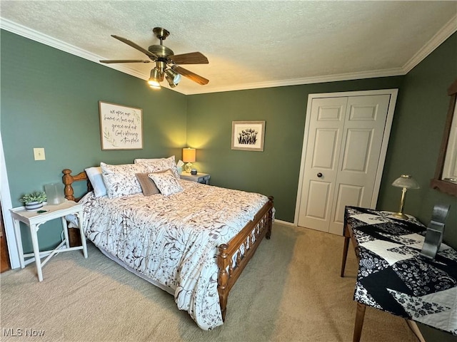 carpeted bedroom featuring a textured ceiling, a closet, crown molding, and ceiling fan