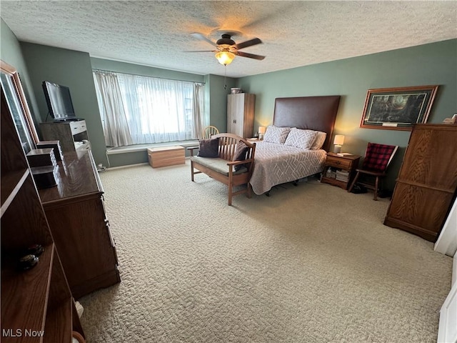 bedroom with ceiling fan, carpet floors, and a textured ceiling