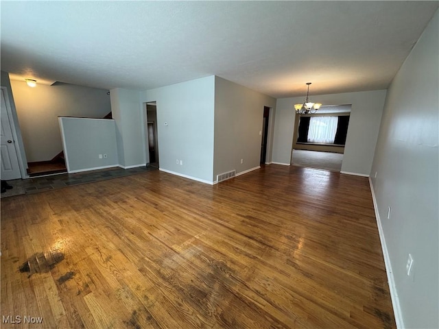 unfurnished room featuring dark hardwood / wood-style floors and a notable chandelier