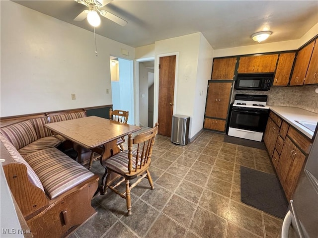 kitchen featuring backsplash, white range with gas cooktop, and ceiling fan