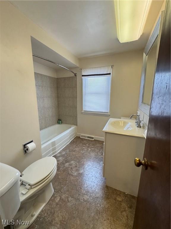 full bathroom featuring vanity, toilet, and tiled shower / bath combo