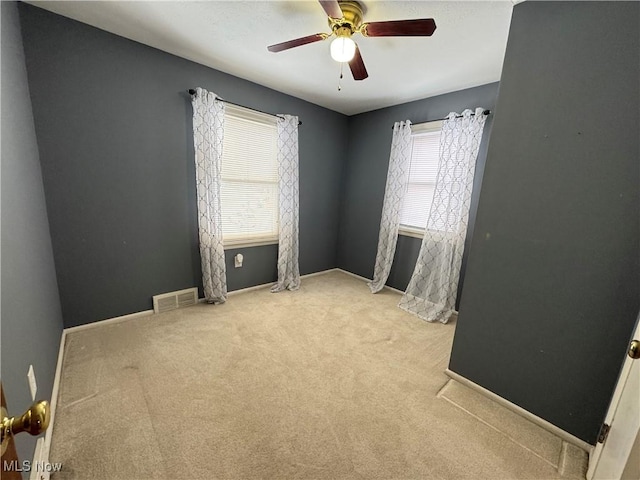 carpeted spare room featuring ceiling fan