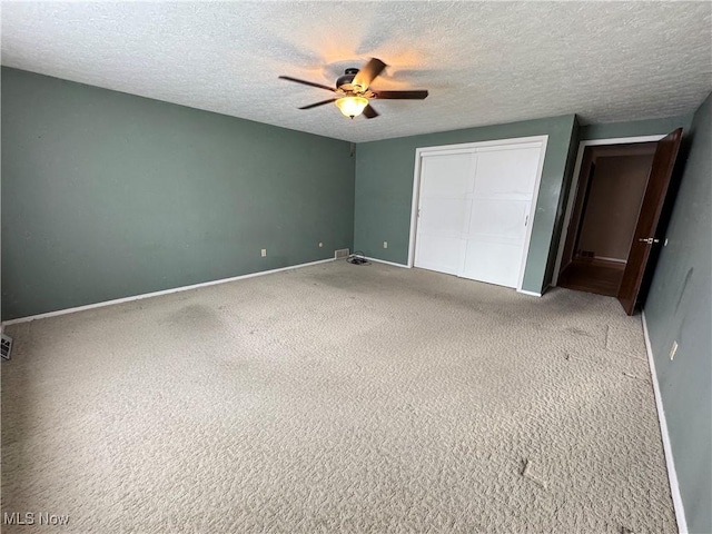 unfurnished bedroom with carpet flooring, ceiling fan, and a textured ceiling