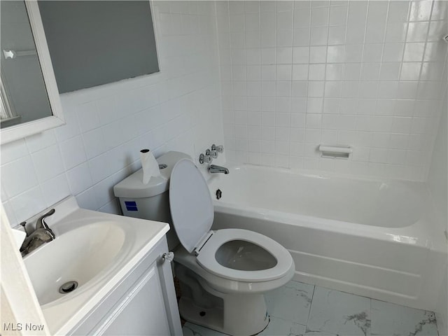 full bathroom with vanity, toilet, tile walls, and tiled shower / bath combo