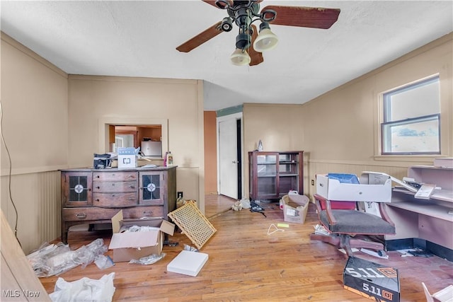 office featuring light hardwood / wood-style floors, ceiling fan, and wood walls