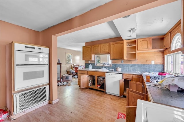 kitchen with decorative backsplash, sink, white appliances, and light wood-type flooring