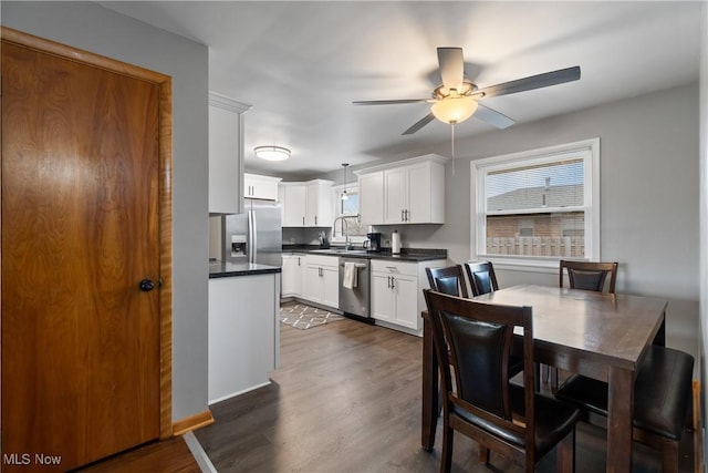 kitchen featuring sink, stainless steel appliances, hanging light fixtures, dark hardwood / wood-style floors, and white cabinets