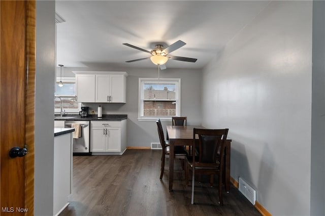 dining space featuring ceiling fan, dark wood-type flooring, and sink