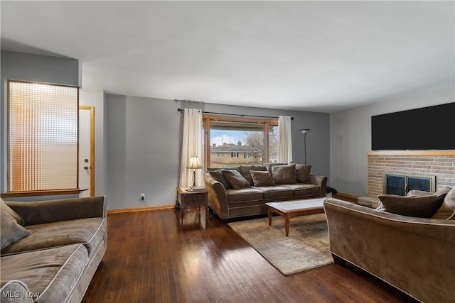 living room featuring wood-type flooring and a brick fireplace