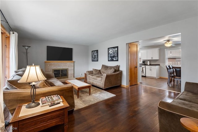 living room with ceiling fan, a fireplace, a healthy amount of sunlight, and dark hardwood / wood-style floors