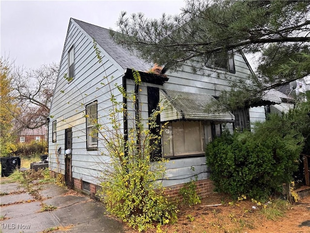 view of side of home featuring roof with shingles