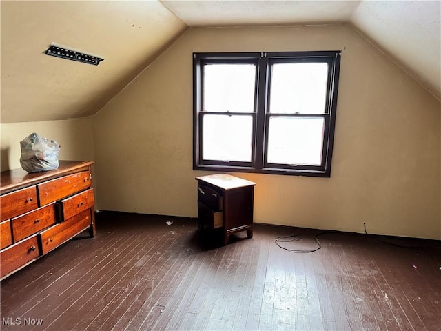 additional living space featuring vaulted ceiling and dark hardwood / wood-style floors