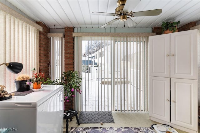 doorway with light carpet and brick wall