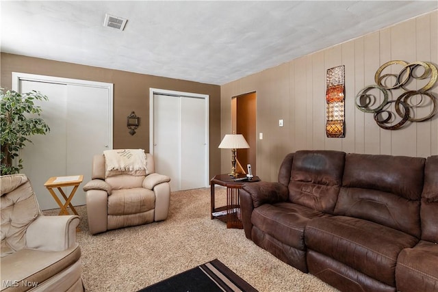 living room with carpet floors and wooden walls